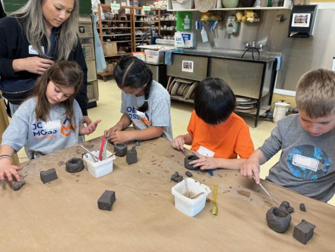 Volunteering with students working on clay project